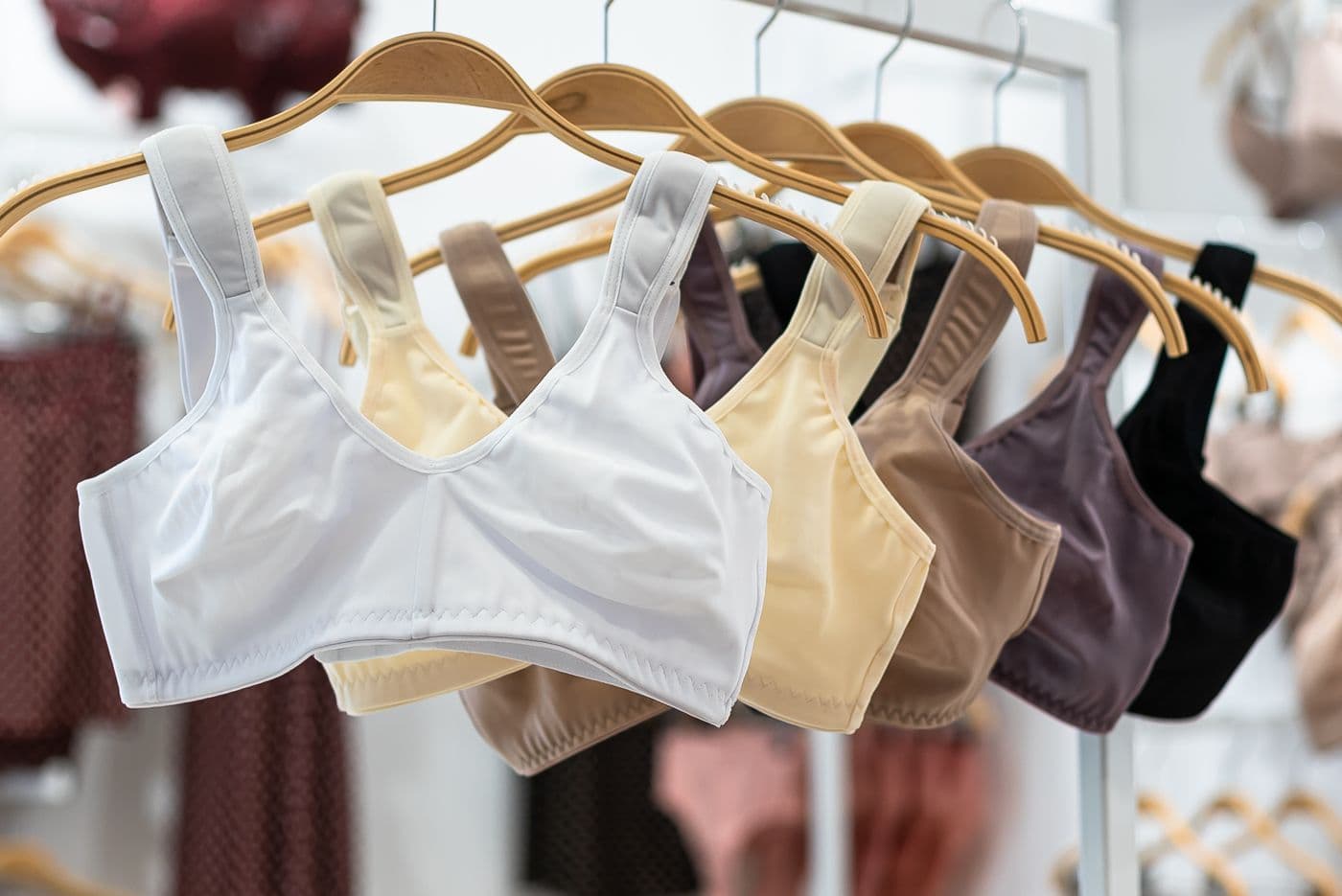 Assorted sports bras on wooden hangers