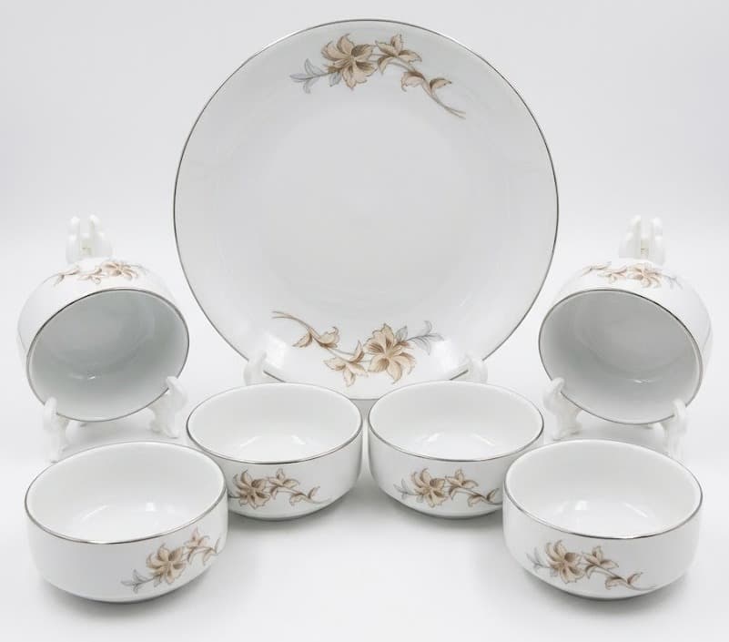 White porcelain dinner set with beige floral motif including plate, cups and bowls