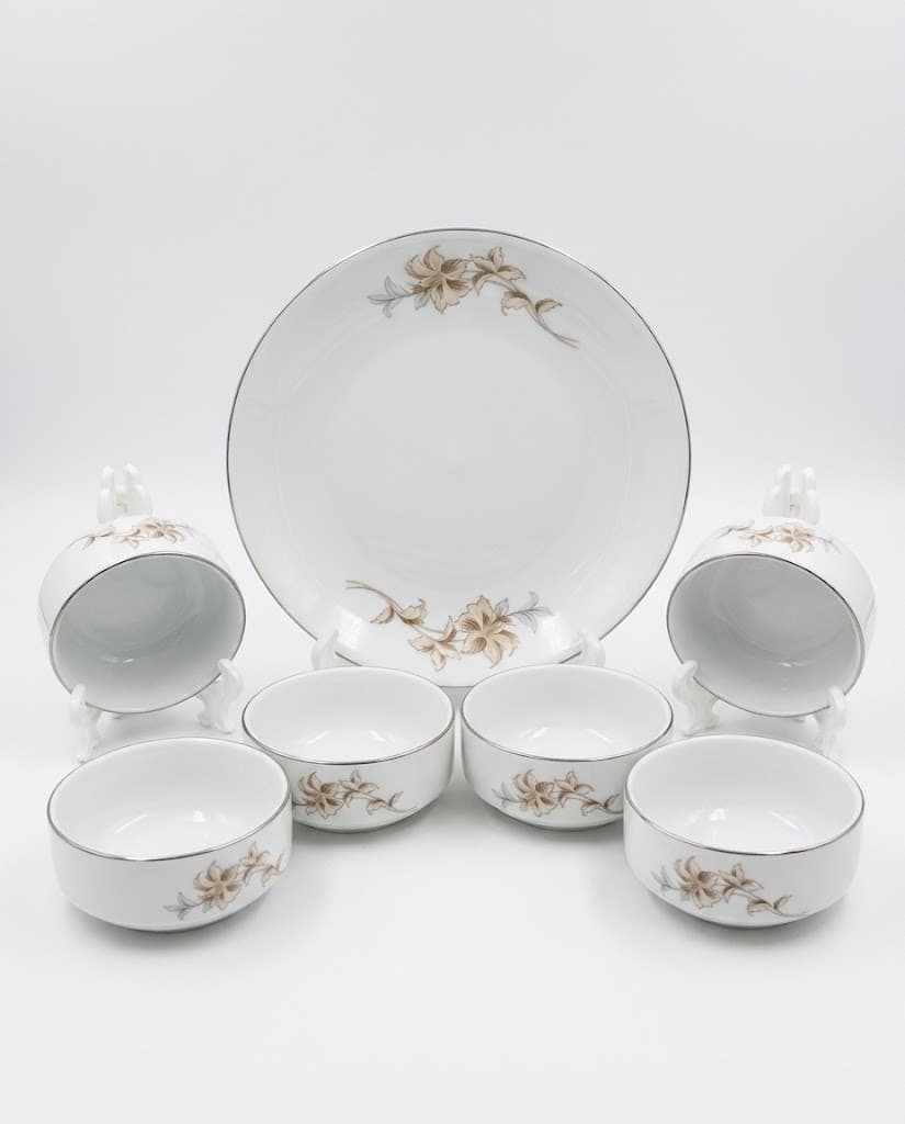 White porcelain dinner set with beige floral motif including plate, cups and bowls
