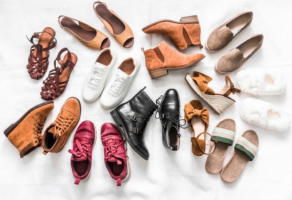 Women's footwear flat lay with boots, sneakers, sandals, heels and flats