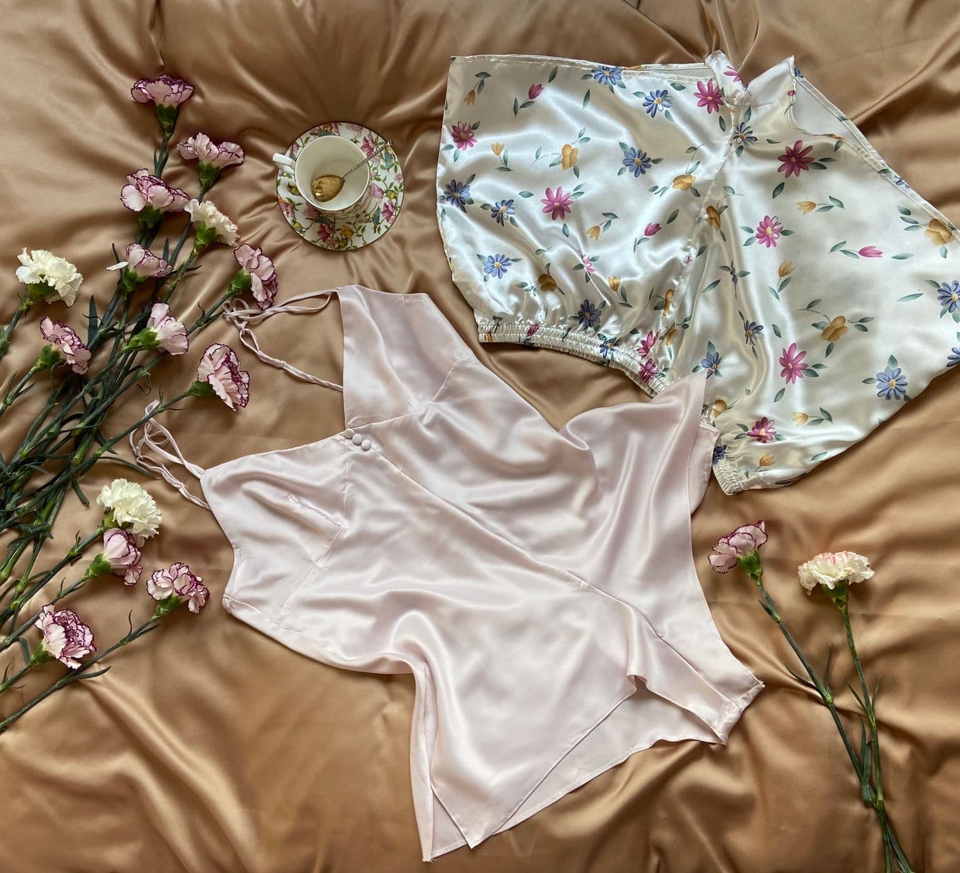 Floral silk pajama set and camisole flat lay with flowers