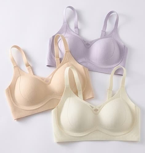 Three wirefree soft-cup bras in lilac, beige and cream