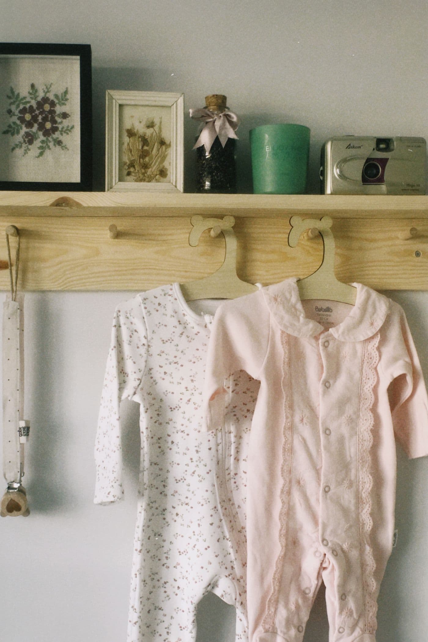 Baby rompers hanging on a wall shelf