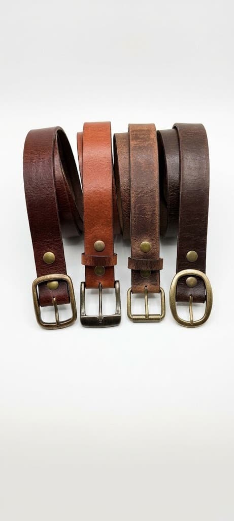 Four coiled leather belts with brass buckles in brown, tan and dark brown shades