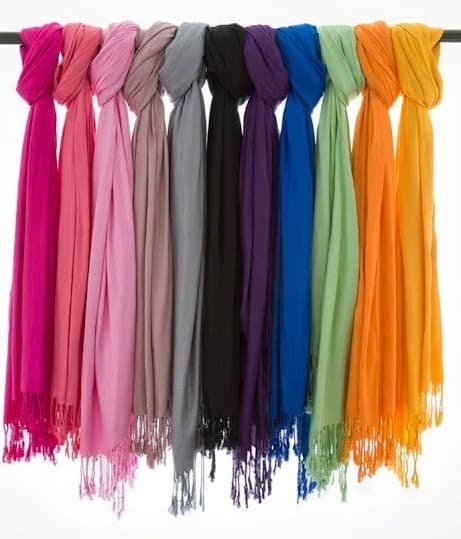 Colorful women's cotton scarves hanging in a row on a rod