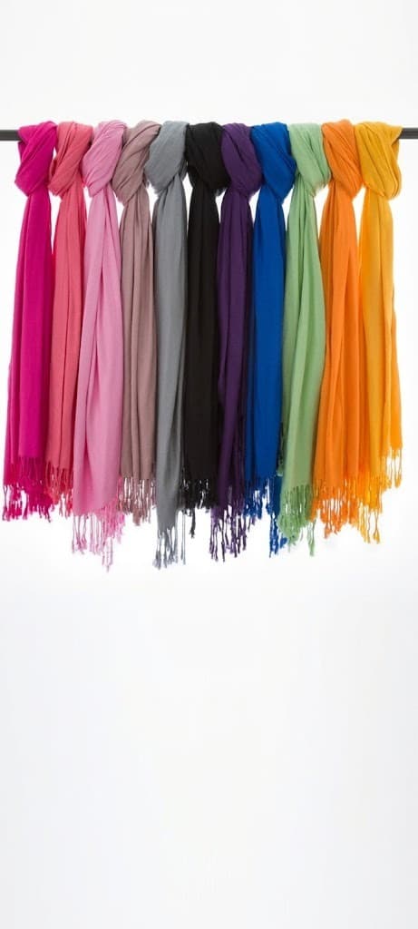 Colorful women's cotton scarves hanging in a row on a rod