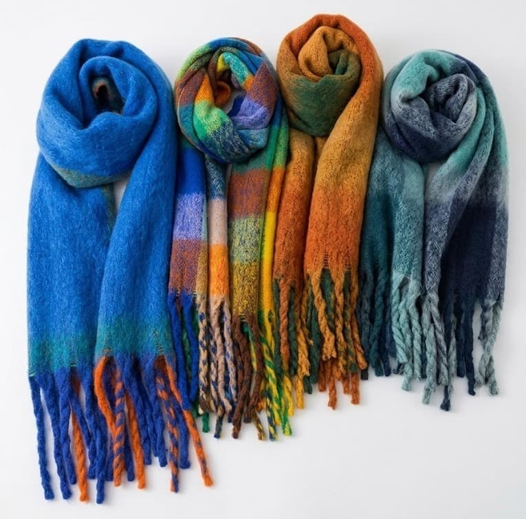 Four fringed wool-blend scarves in blue, multicolor plaid, orange and teal on white background