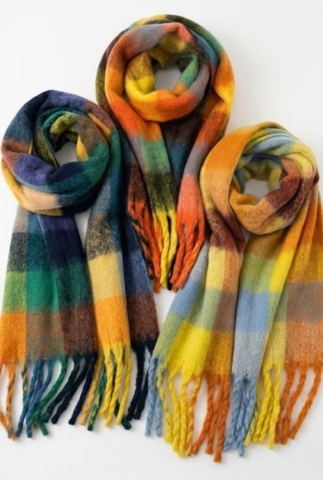 Three fringed plaid brushed scarves in yellow, green and navy tones on white background