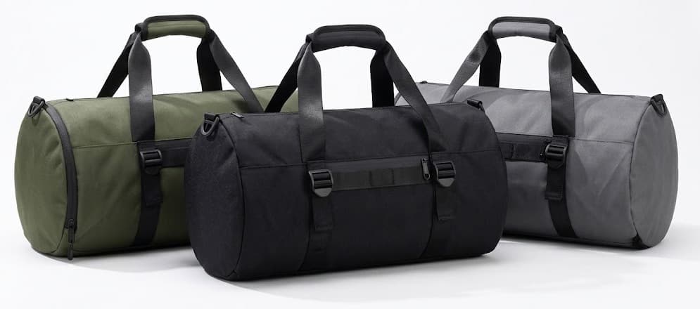Three canvas duffel travel bags in olive green, black and gray on white background