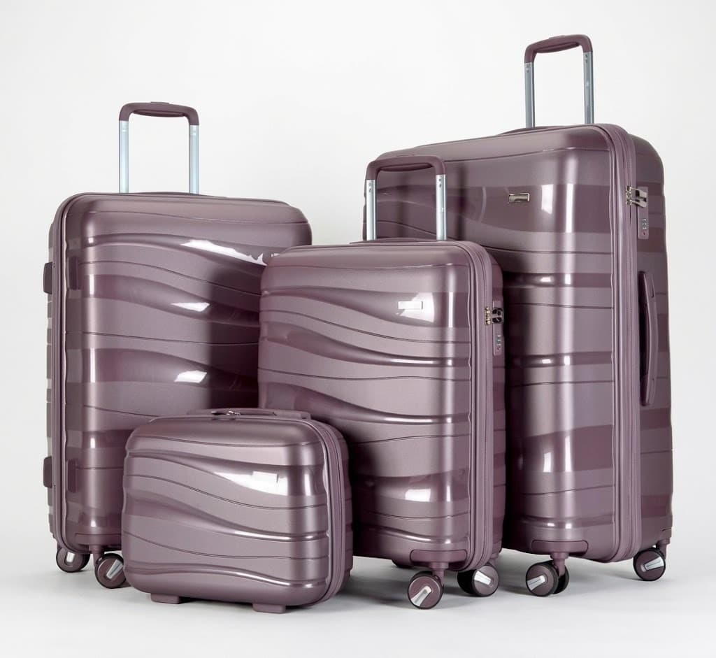 Four-piece mauve hard-shell spinner luggage set with wavy texture on white background